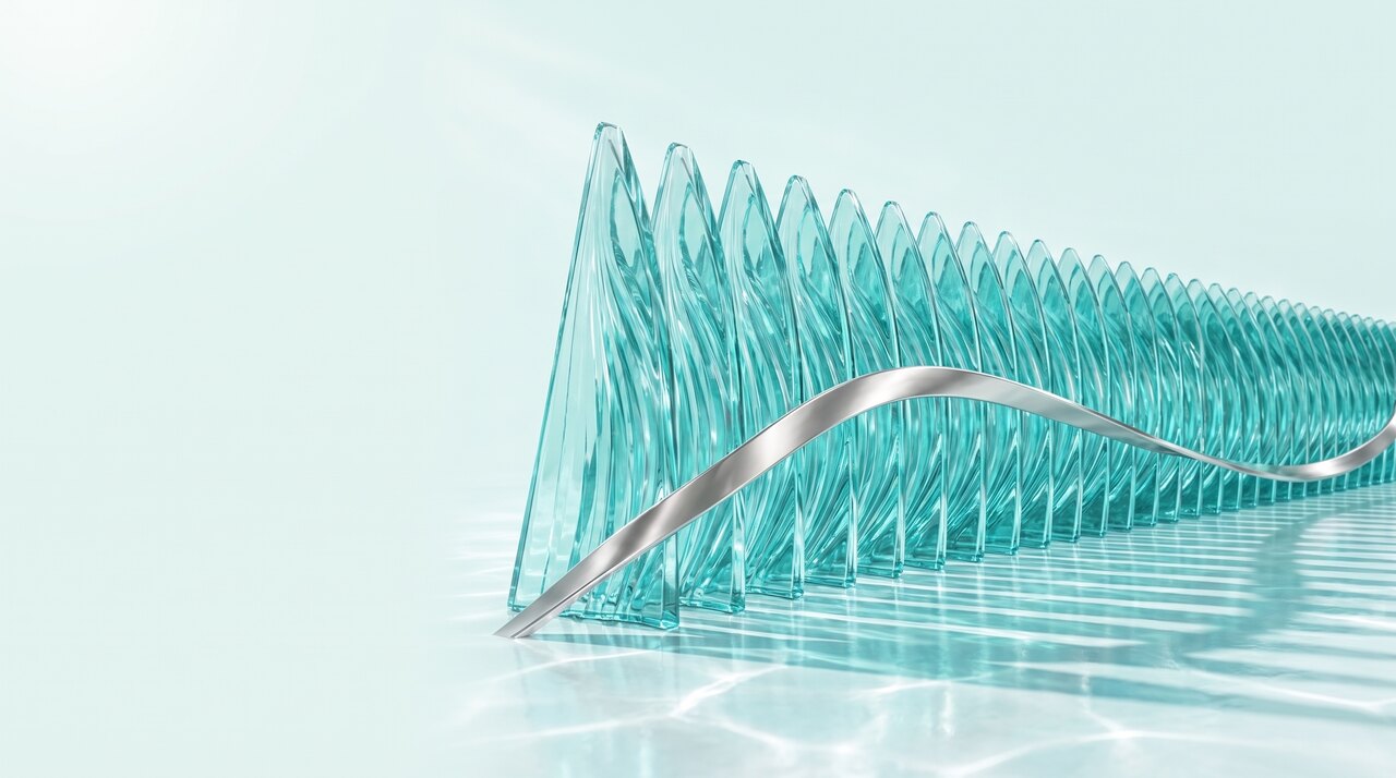 A material study in bright daylight. A long rank of triangular clear turquoise glass fins steps away to the right, a polished pearl silver ribbon threading over and under them in one continuous wave, standing on a rippled pale floor.